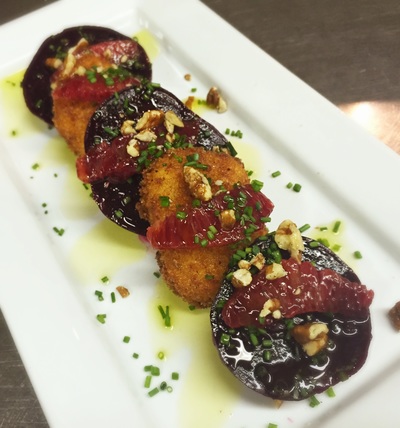 roasted beet small plate: layers of roasted beets and crispy fried goat cheese rounds topped with toasted walnuts, chives and blood orange segments
