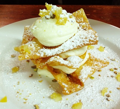 cannoli tower: 3 layers of crispy cannoli pastry and cannoli cream topped with powdered sugar and pistachios